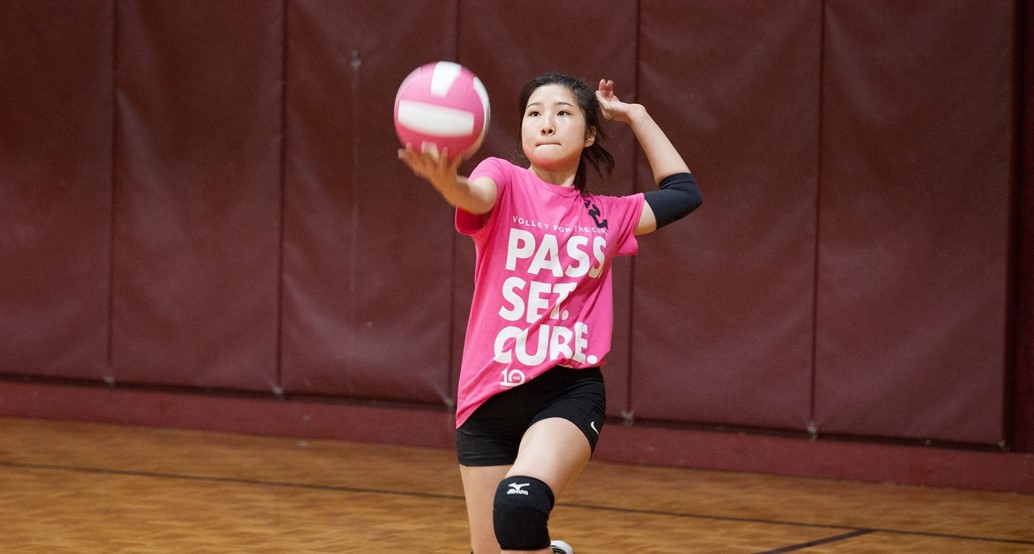 student serving volleyball