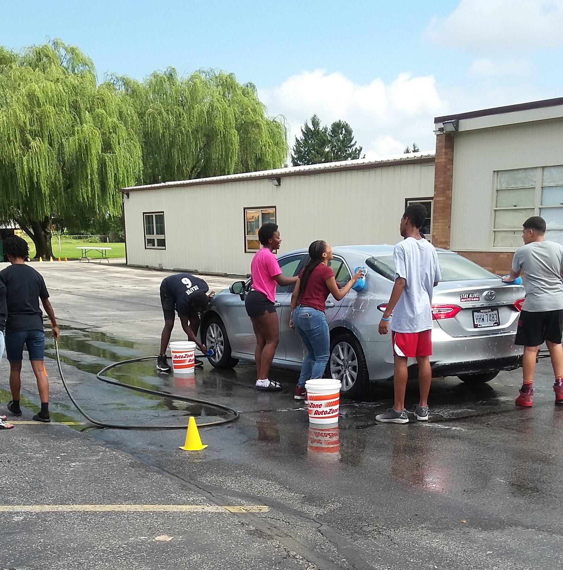 students washing a car