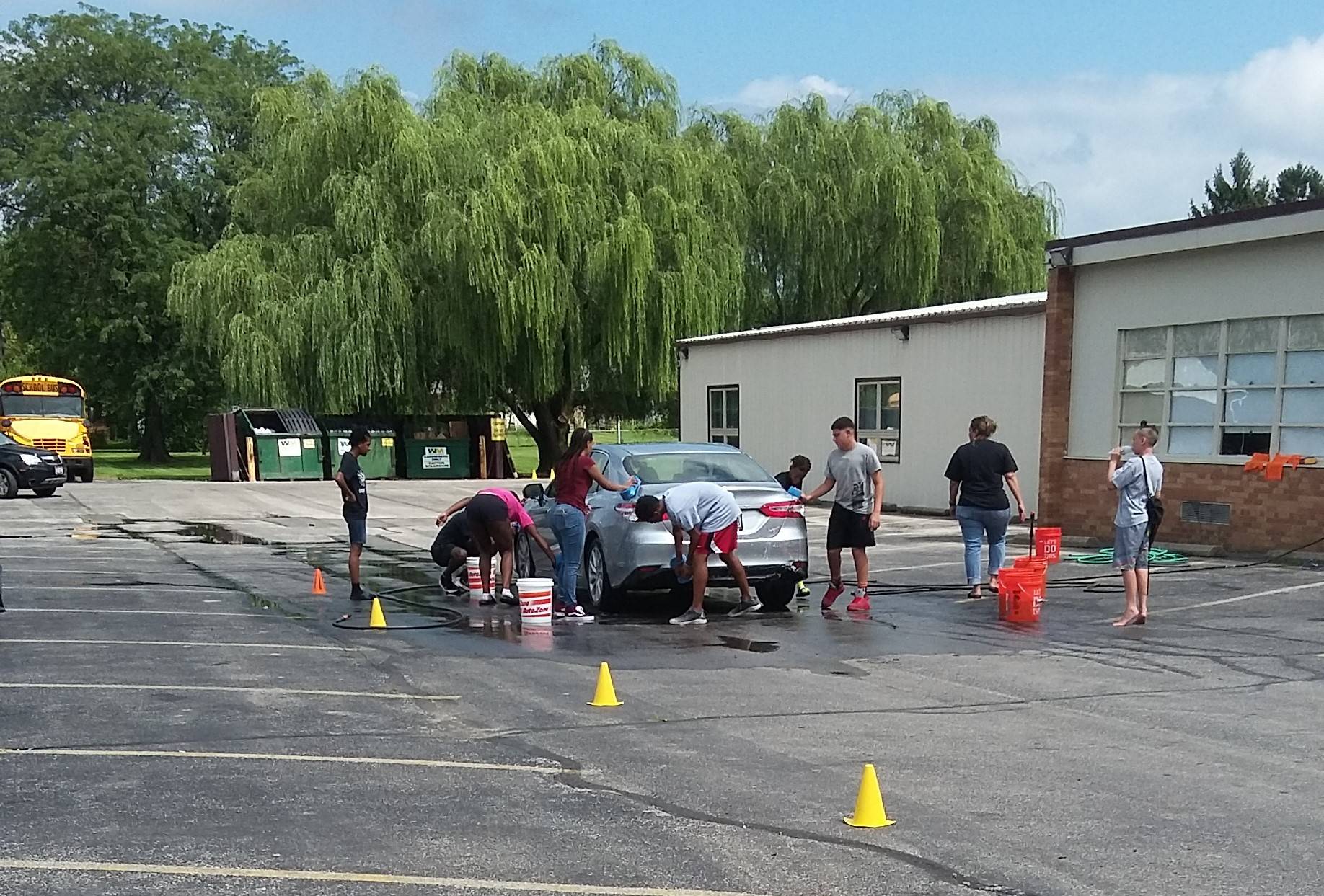 students washing a car